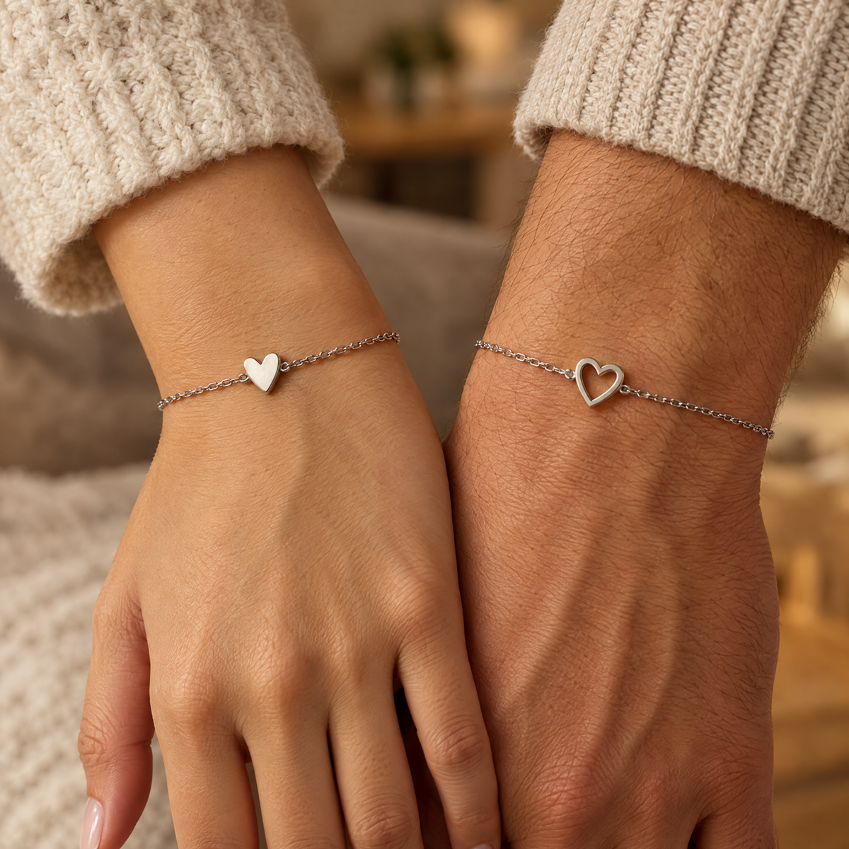 Bracelets cœurs assortis argentés portés par un couple
