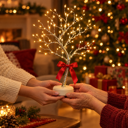 Lampe arbre de vie LED offerte avec un nœud rouge devant le sapin de Noël
